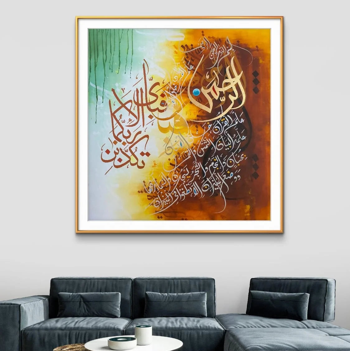 Framed calligraphy artwork on a wall above a gray sofa in a living room.